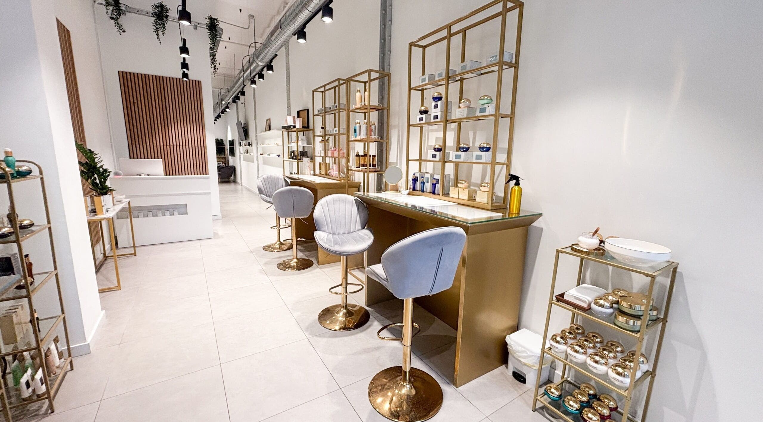 Interior elegante de Premier Experience en Barcelona, Catalunya, ES con sillas y estanterías doradas.