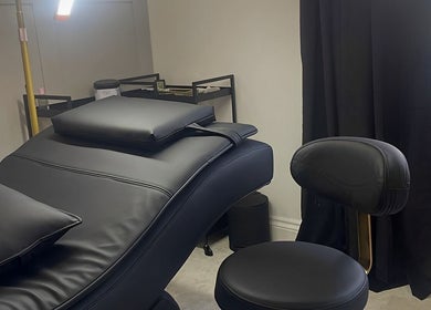 Luxury treatment room at Xlashedbykatiex in Ponteland, England, GB featuring a sleek black chair and modern decor.