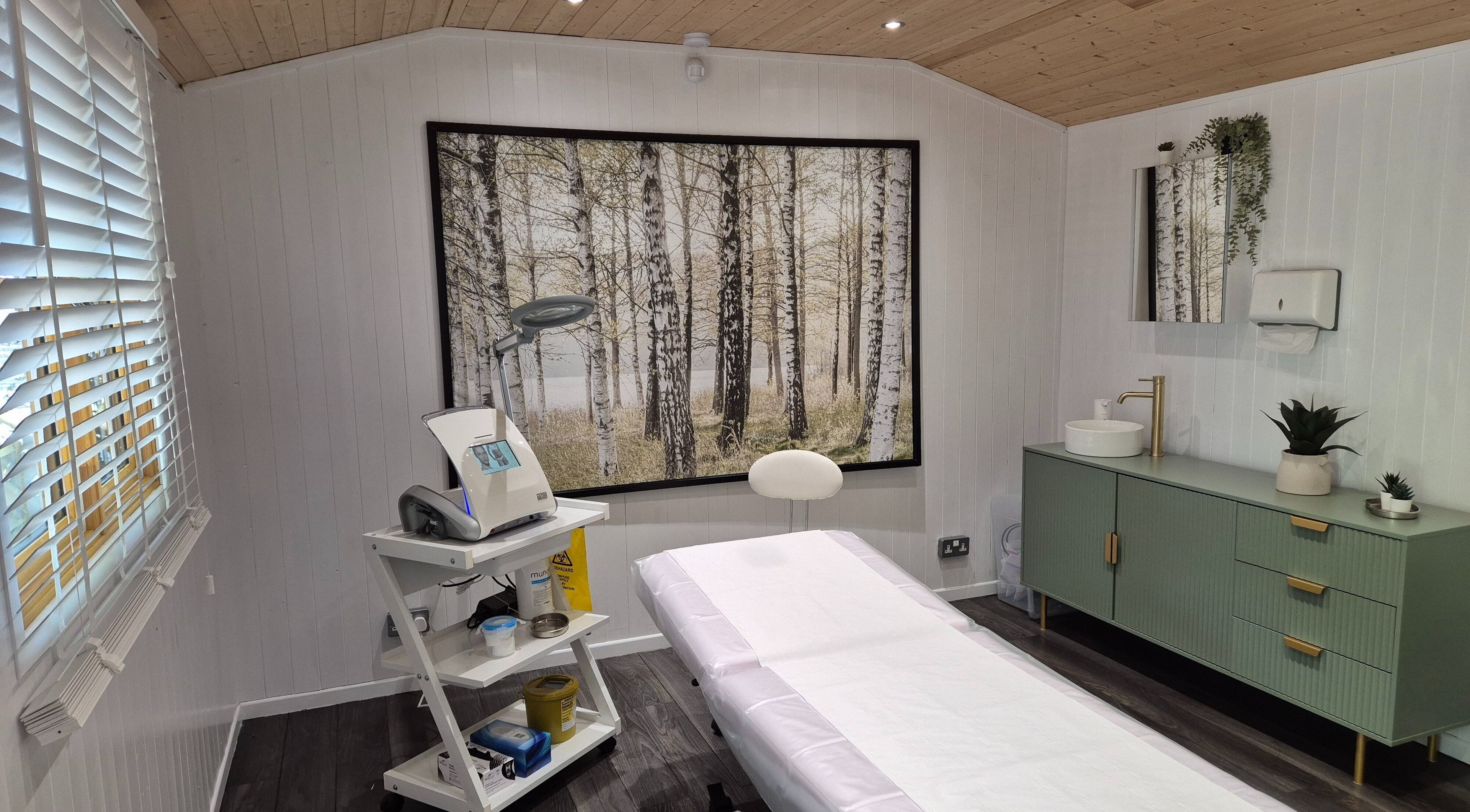 Sleek treatment room at ElectroGlow Studio, Well Hill, England with a tranquil forest mural.