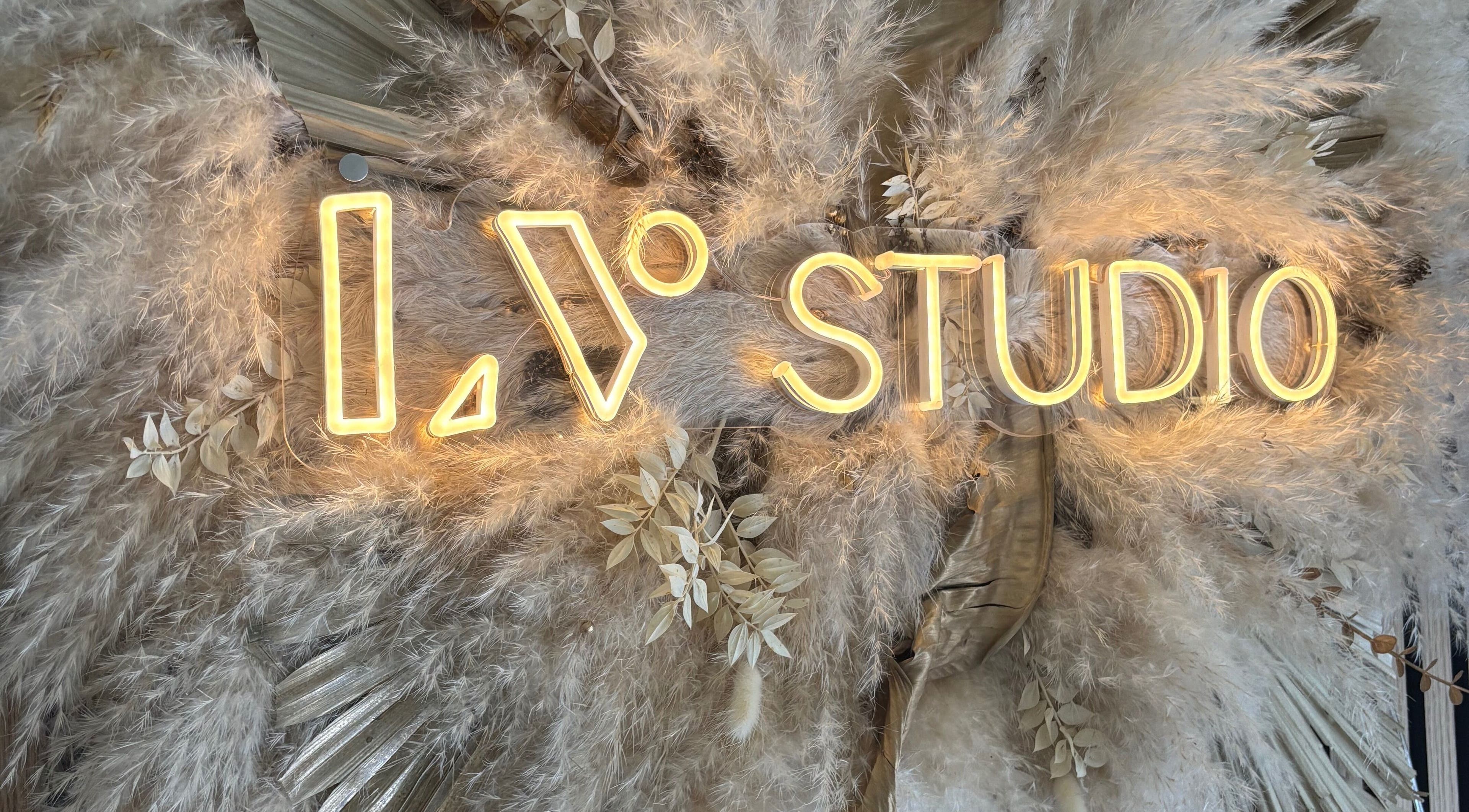 Neonbord met 'LV Studio' omringd door pluimen, gelegen in Willemstad, CW.