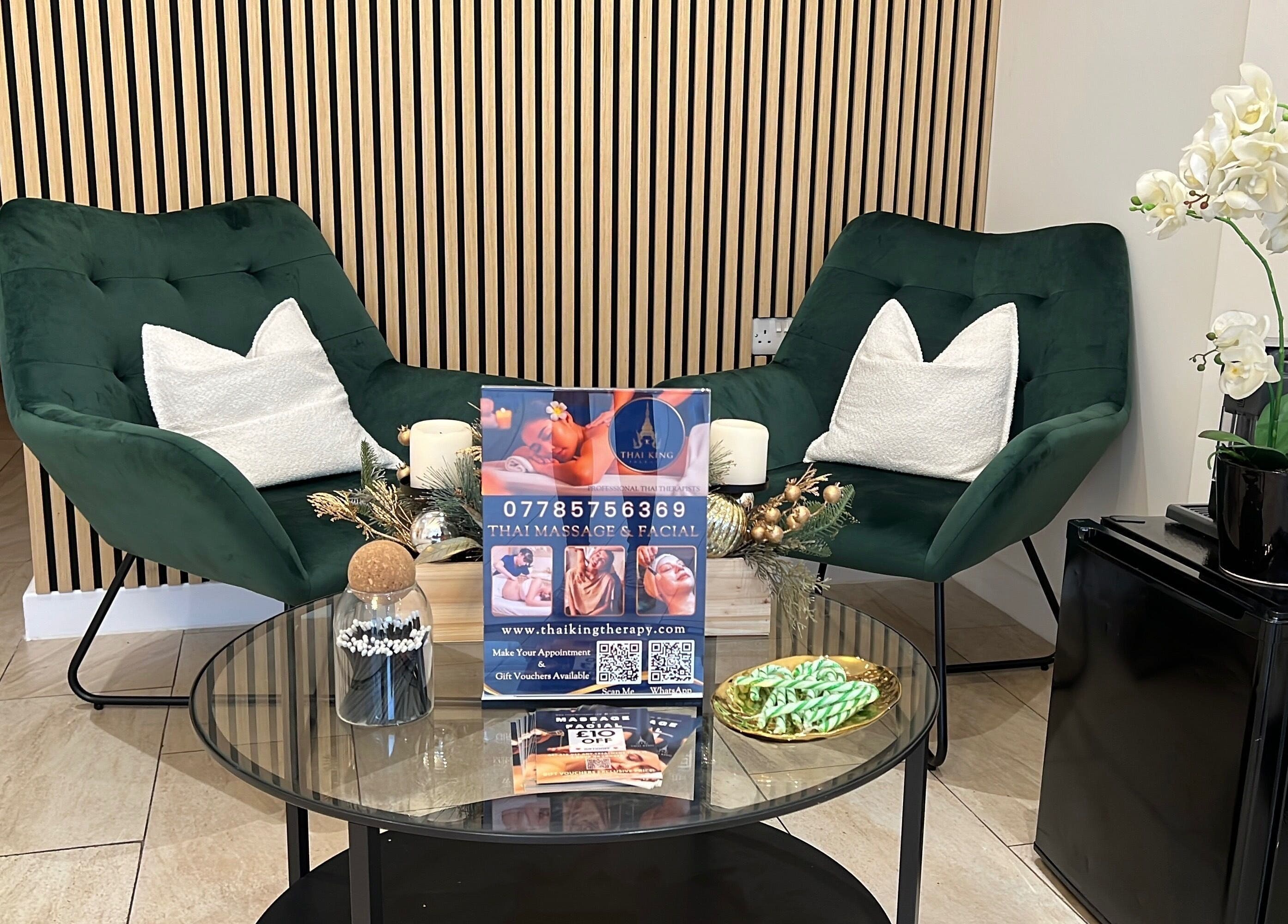 Cozy seating area at THAI KING THERAPY MASSAGE, Reading, England, featuring green chairs and elegant decor.