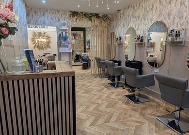 Elegant interior of L'abeille Hair & Beauty in Halifax, England features styling stations with mirrors and floral decor.