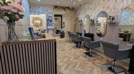 Elegant interior of L'abeille Hair & Beauty in Halifax, England features styling stations with mirrors and floral decor.
