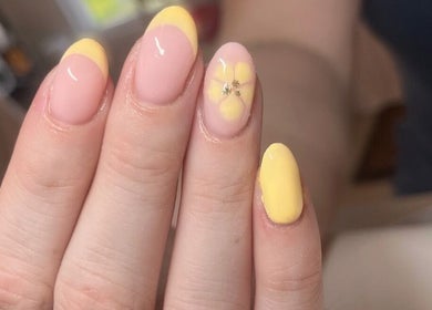 Yellow floral nail art at Glam By TAM, Stevenage, England, GB showcases elegant beauty trends.