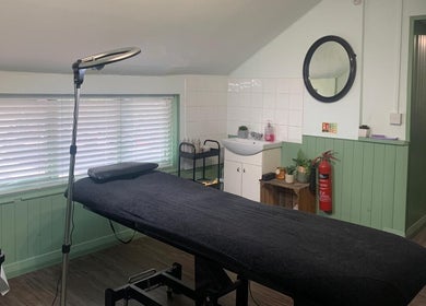 Treatment room at The Stock Room Hair & Beauty, Norwich, England, GB, featuring a massage table and cozy décor.