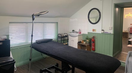 Treatment room at The Stock Room Hair & Beauty, Norwich, England, GB, featuring a massage table and cozy décor.