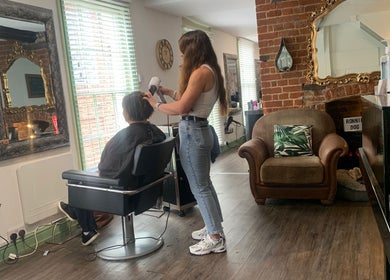Stylist at The Stock Room Hair & Beauty, Norwich, England, GB, blow-drying a client’s hair in a stylish salon.