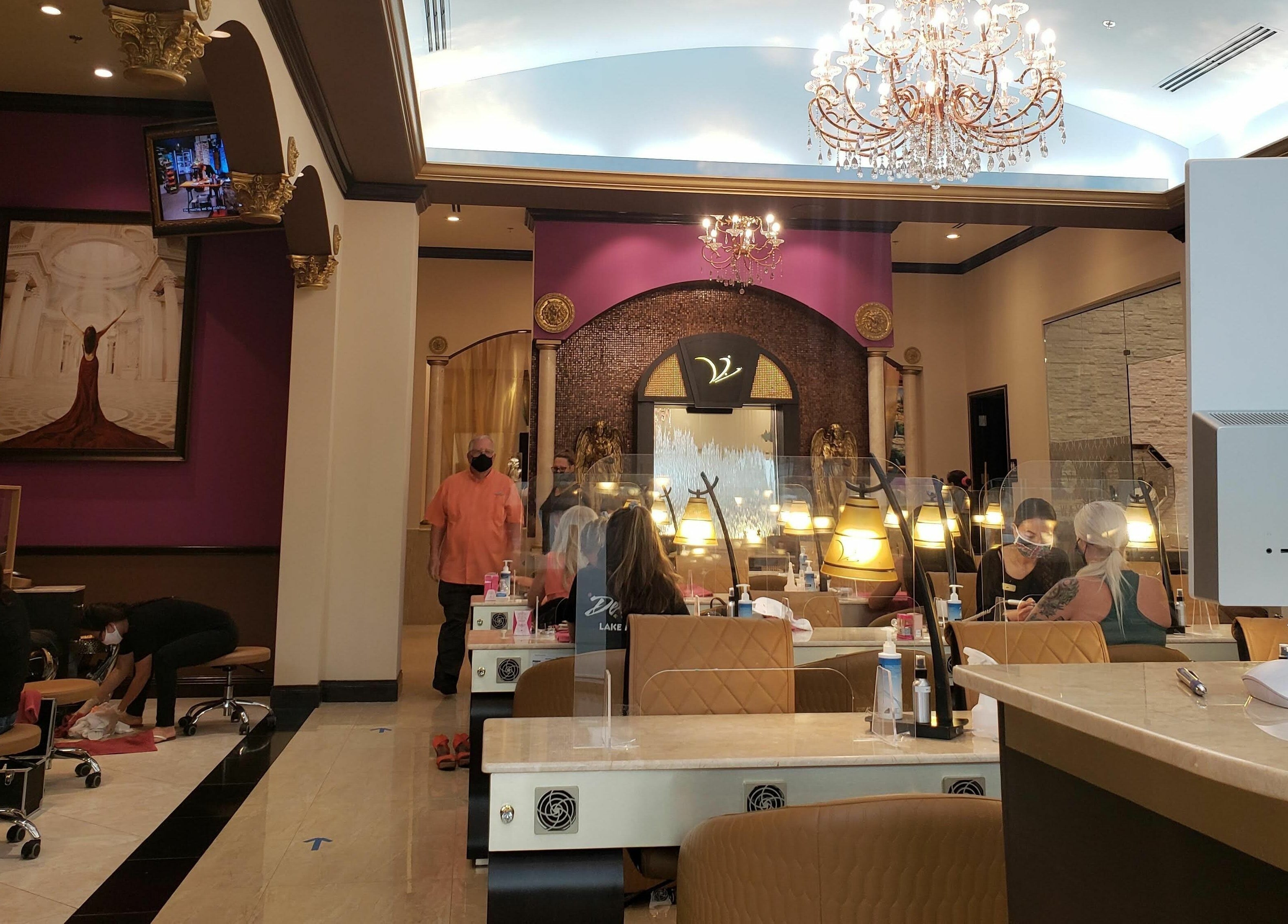 Elegant interior of Venetian Nail Spa in Daytona Beach, Florida, US with nail stations and chandeliers.