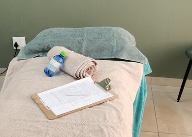 Massage bed setup with towels and water at Calmm Massage, Sandton, Gauteng, ZA.