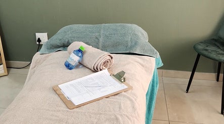 Massage bed setup with towels and water at Calmm Massage, Sandton, Gauteng, ZA.