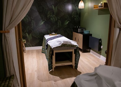 Relaxing massage room at Kimyra Thai Massage & Spa, Waltham Abbey, England, GB, featuring warm lighting and tropical decor.