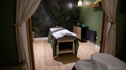 Relaxing massage room at Kimyra Thai Massage & Spa, Waltham Abbey, England, GB, featuring warm lighting and tropical decor.