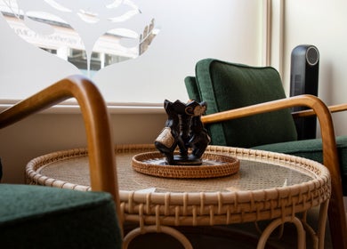 Tranquil seating area at Kimyra Thai Massage & Spa, Waltham Abbey, England, GB, featuring green chairs and a table.