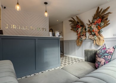 Reception at J Belle Beauty in Bromley, England with floral decor and luxurious seating.