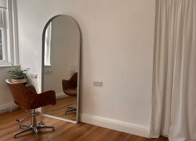Chic salon chair by full-length mirror at Mantra, Leeds, England, GB, reflecting minimalist elegance.