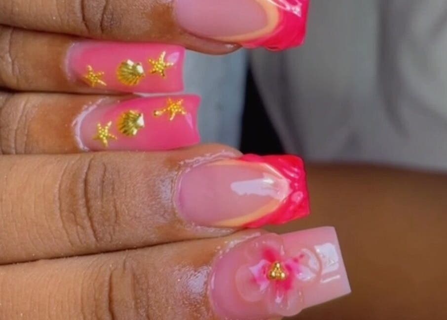 Diseño de uñas con motivos dorados y rosados en Studio India Nails en Willemstad, Curazao, CW.