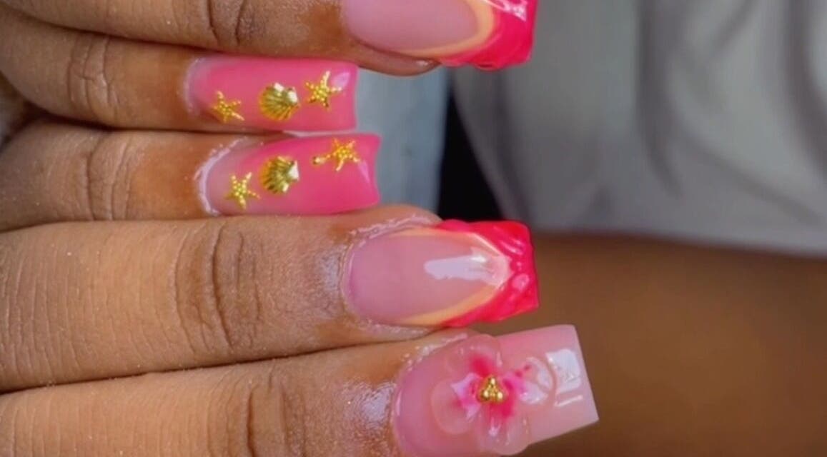 Diseño de uñas con motivos dorados y rosados en Studio India Nails en Willemstad, Curazao, CW.