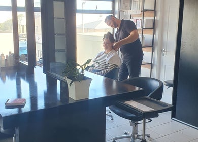 A hairstylist attends to a client at Y & Co. SKIN - HAIR - NAILS in Yzerfontein, Western Cape, ZA.