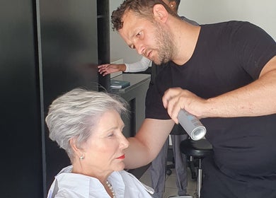Professional hairstylist at Y & Co. SKIN - HAIR - NAILS in Yzerfontein, Western Cape, ZA, styling a client's hair.