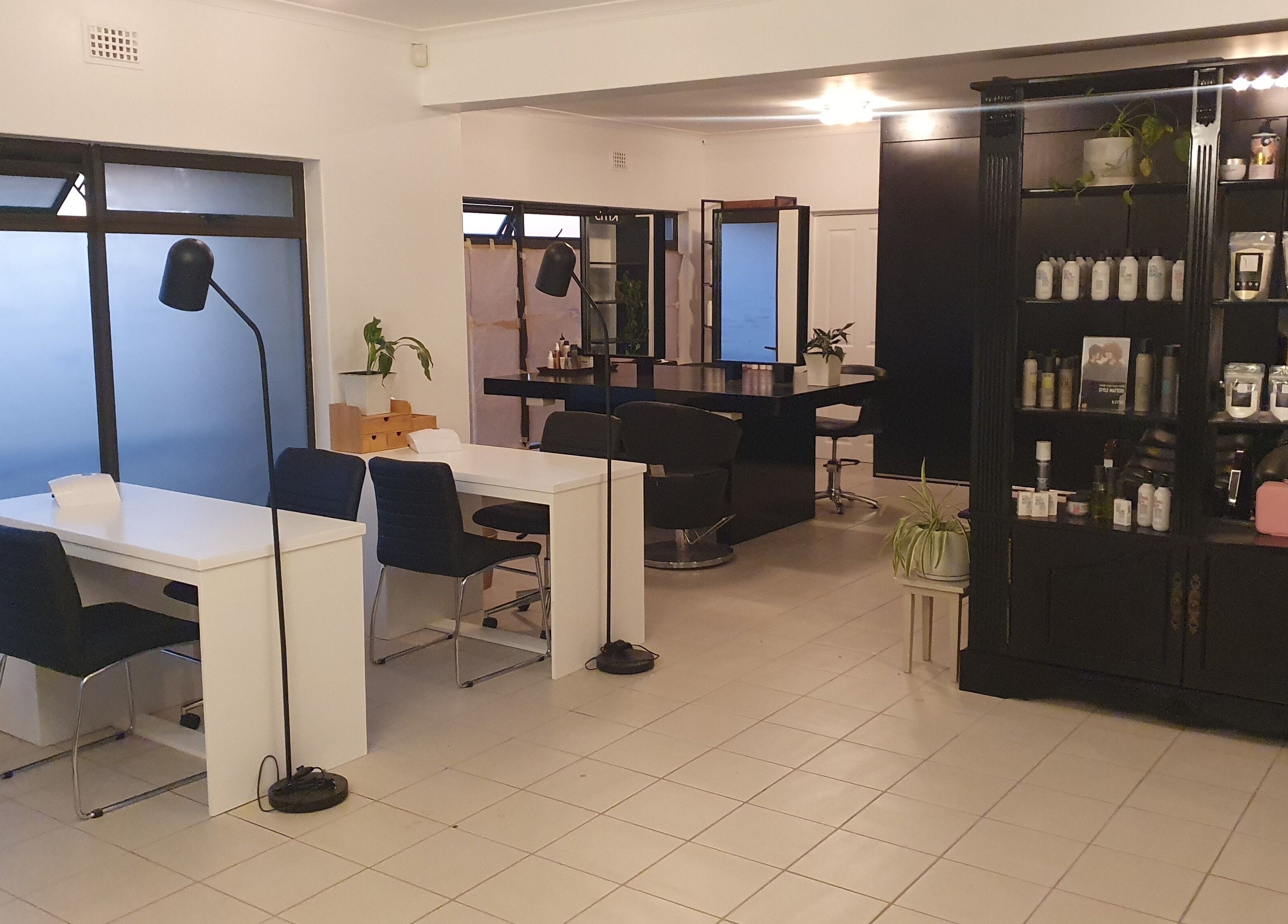 Interior of Y & Co. SKIN - HAIR - NAILS in Yzerfontein, Western Cape, ZA showcasing modern chairs and shelving.