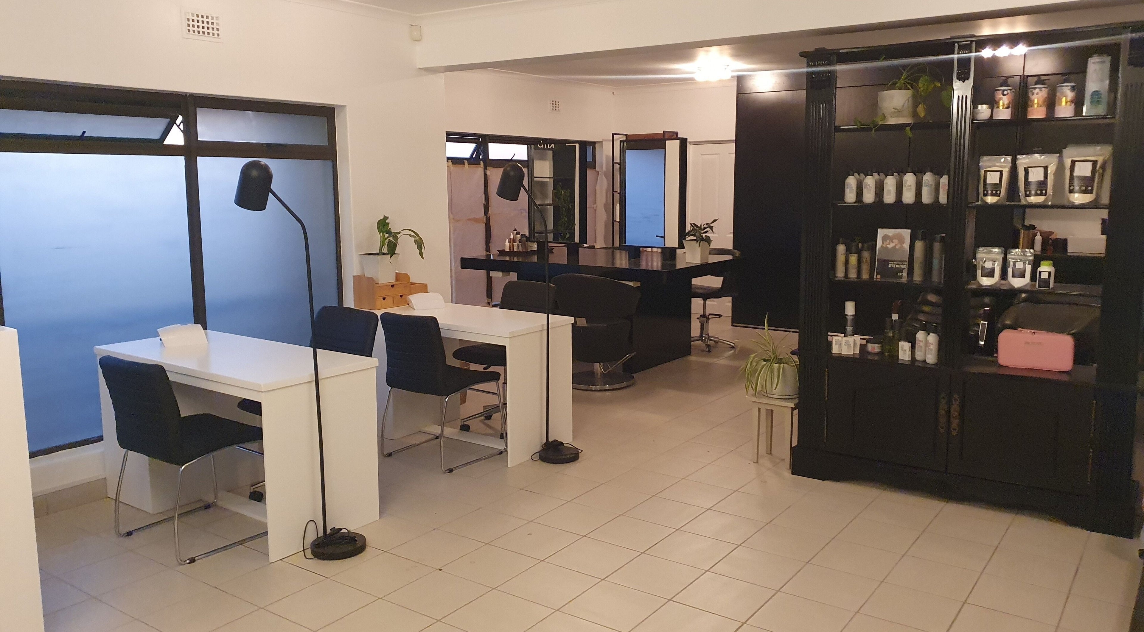 Interior of Y & Co. SKIN - HAIR - NAILS in Yzerfontein, Western Cape, ZA showcasing modern chairs and shelving.