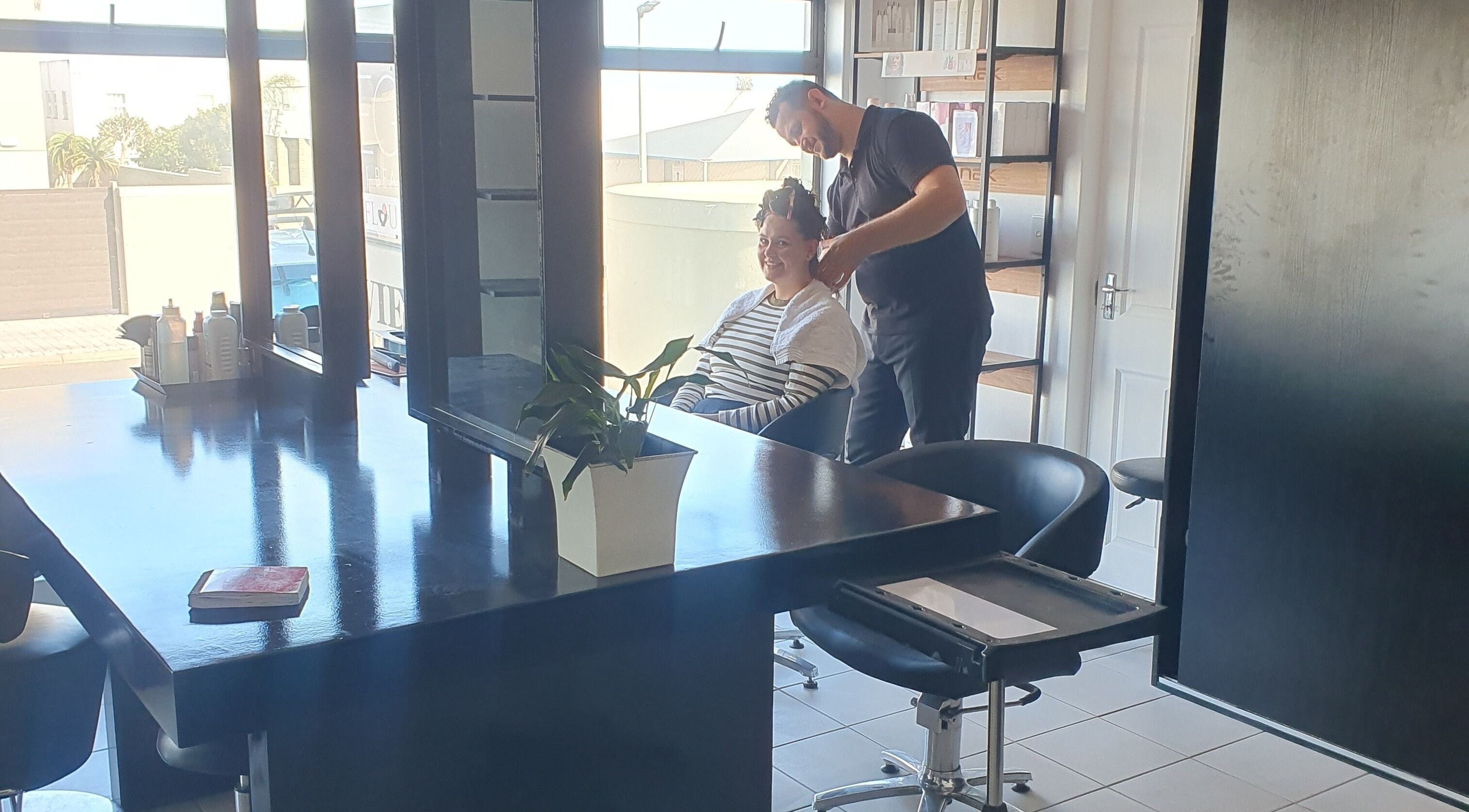 A stylist at work in Y & Co. SKIN - HAIR - NAILS, Yzerfontein, Western Cape, ZA, ensuring client satisfaction.