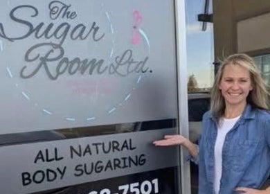 Smiling person outside The Sugar Room Okotoks, a body sugaring venue in Okotoks, Alberta, CA.