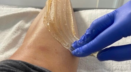 Sugaring treatment at The Sugar Room Okotoks, Alberta, CA, showcasing smooth application on a leg.