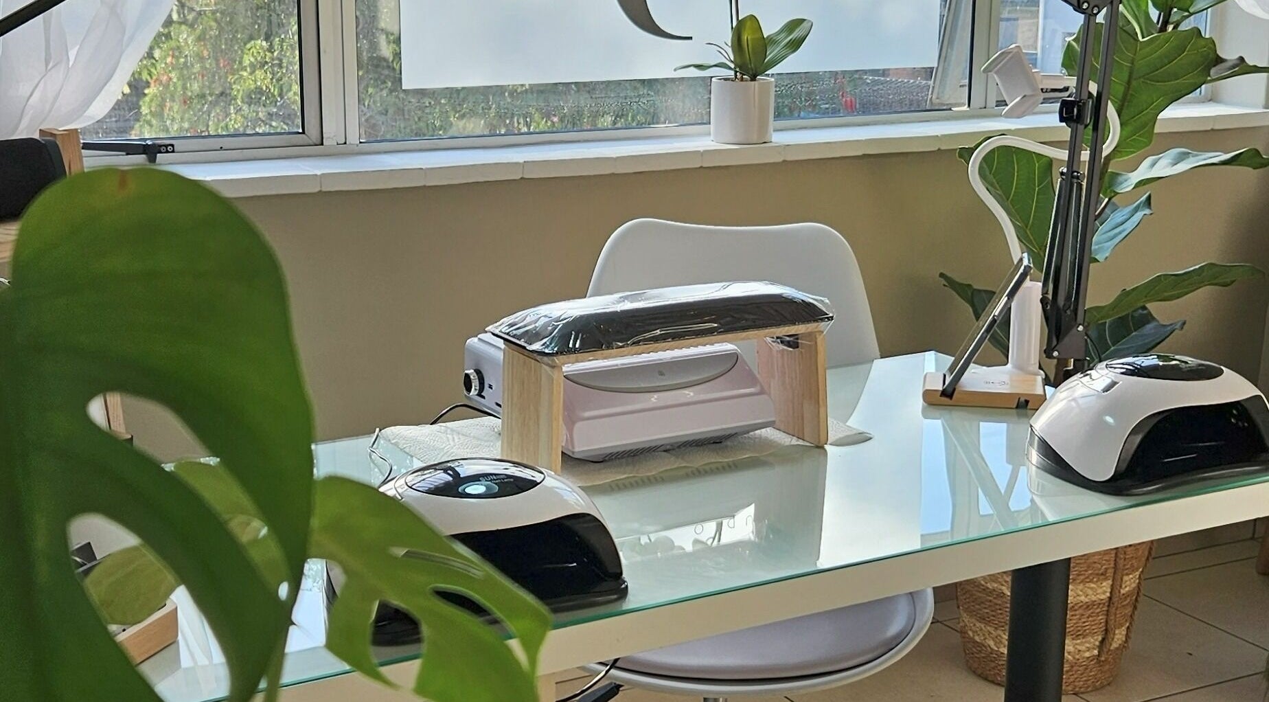 Modern nail station at Sj Studio, Durban, Kwazulu-natal, ZA with manicure tools and lush greenery.