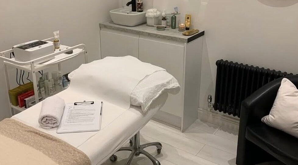 Elegant treatment room at Pure Esthetics in Chester, England, GB, featuring a cozy bed and skincare products.