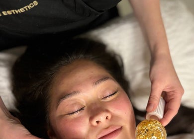 Client enjoying a luxurious facial at Pure Esthetics, Chester, England, GB, showcasing gold therapy.