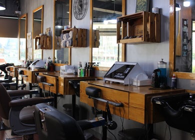Chic interior view of Brusko Barbers' stylish grooming stations, Dubai, AE, with modern amenities.