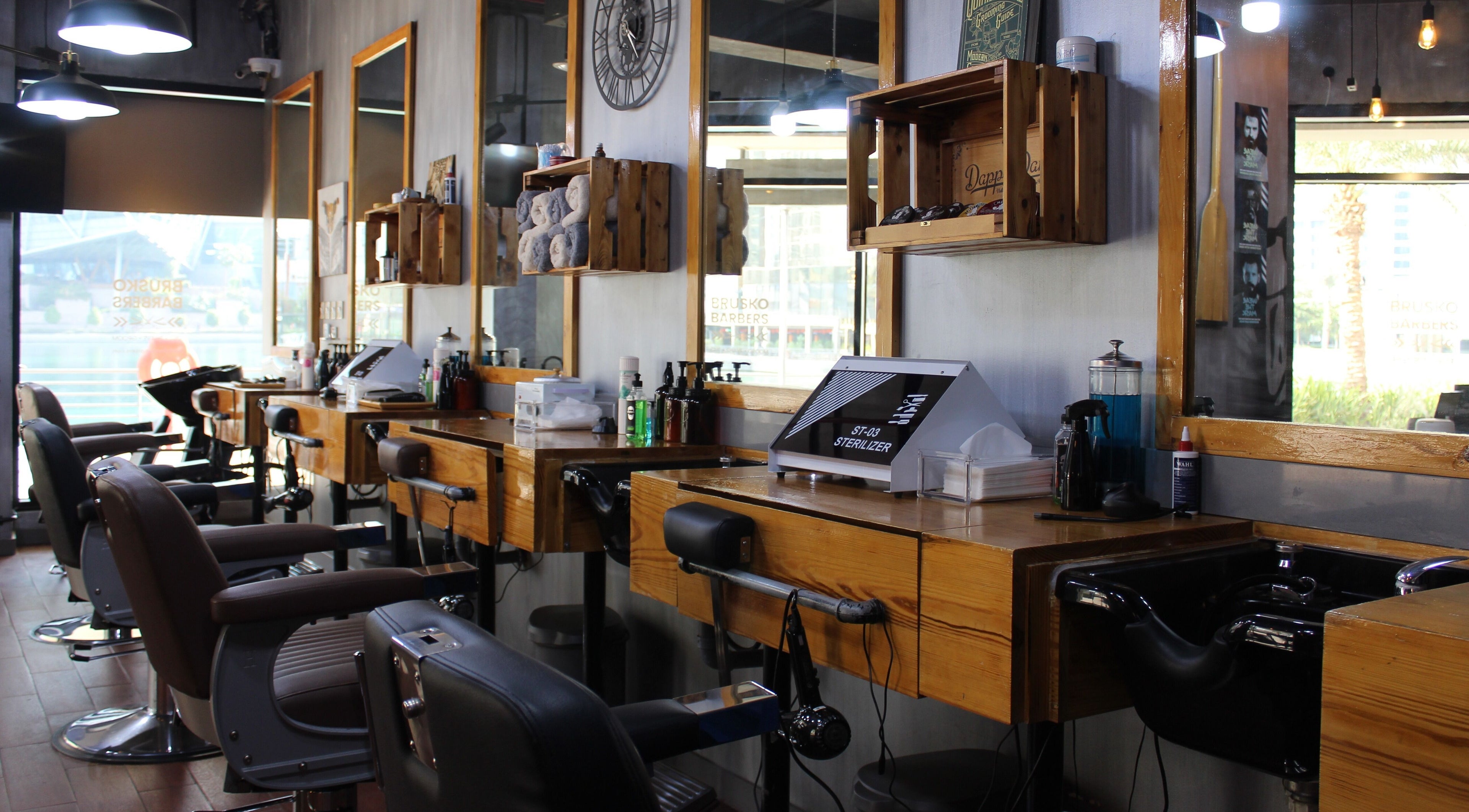 Chic interior view of Brusko Barbers' stylish grooming stations, Dubai, AE, with modern amenities.