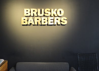 Relaxing seating area at Brusko Barbers, دبي, دبي, AE, featuring a stylish sofa and modern decor.