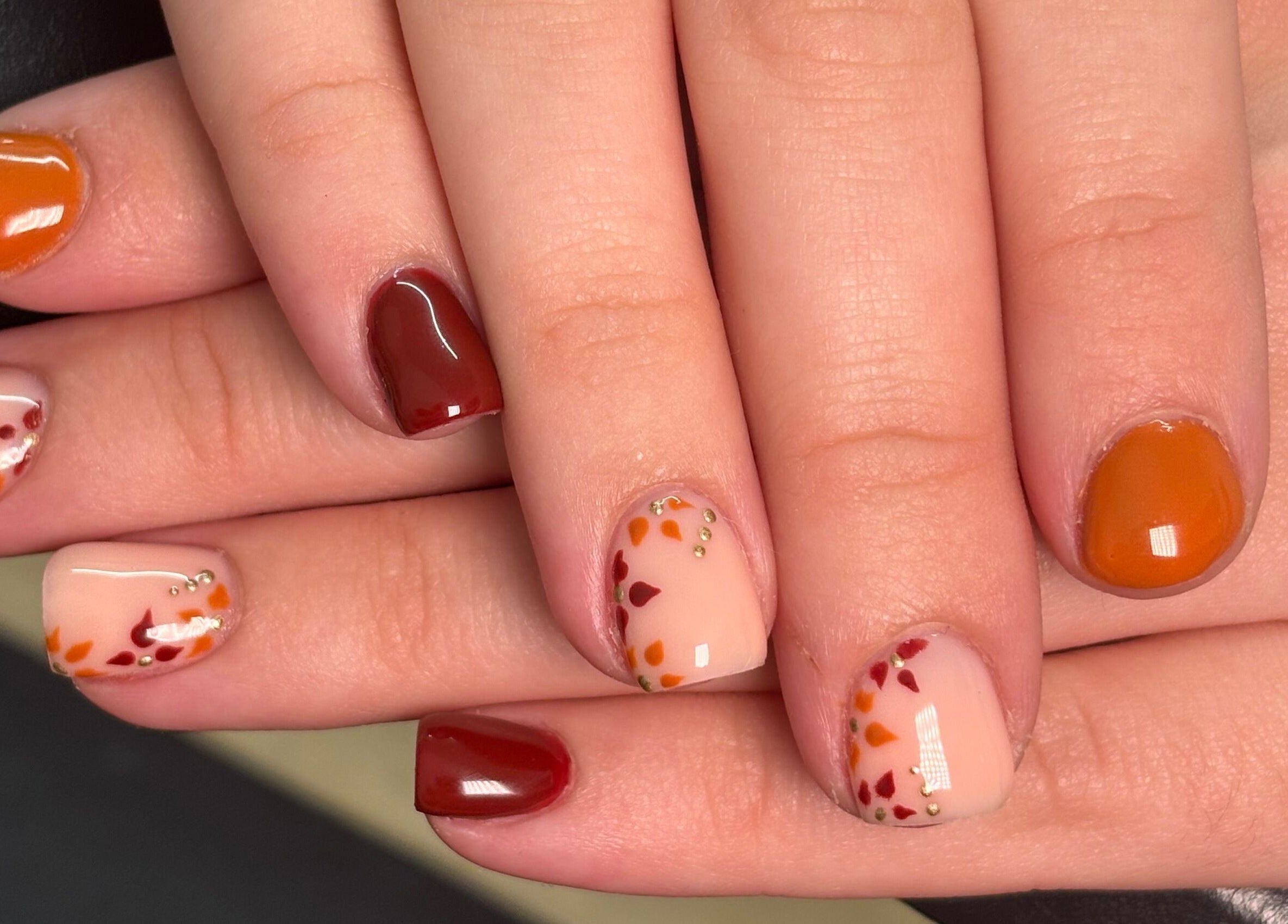 Autumn-themed nail art at A.Luxebeauty, Sheffield, England, GB, featuring warm colors and delicate designs.