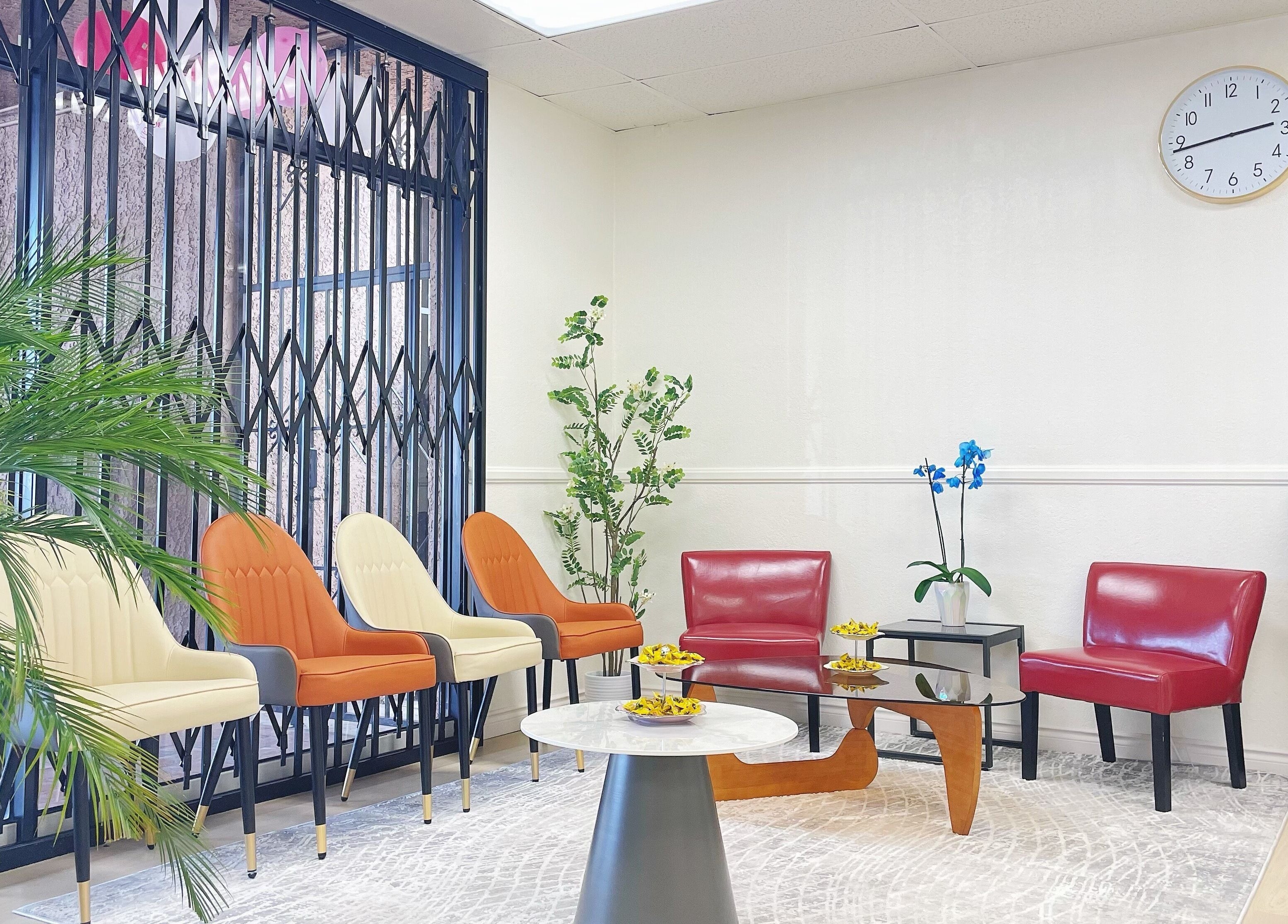 Stylish waiting area at E.Lashes, El Monte, California, US with modern chairs and lush greenery.