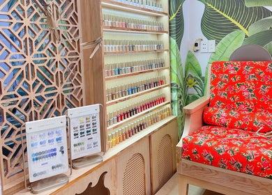 Kệ sơn móng đầy màu sắc tại Thuỳ Thỏ Nail Đà Nẵng, Đà Nẵng, Đà Nẵng, VN với ghế đỏ họa tiết.