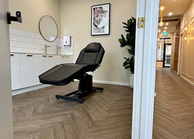 Calm treatment room at X&O Beauty Co, Melbourne, Victoria, AU with a sleek black chair and modern decor.