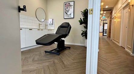 Calm treatment room at X&O Beauty Co, Melbourne, Victoria, AU with a sleek black chair and modern decor.