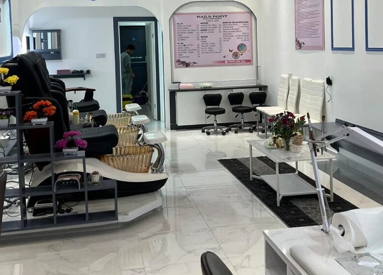 Bright interior of Nails Point, London, England, GB showing chic nail salon chairs and decor.
