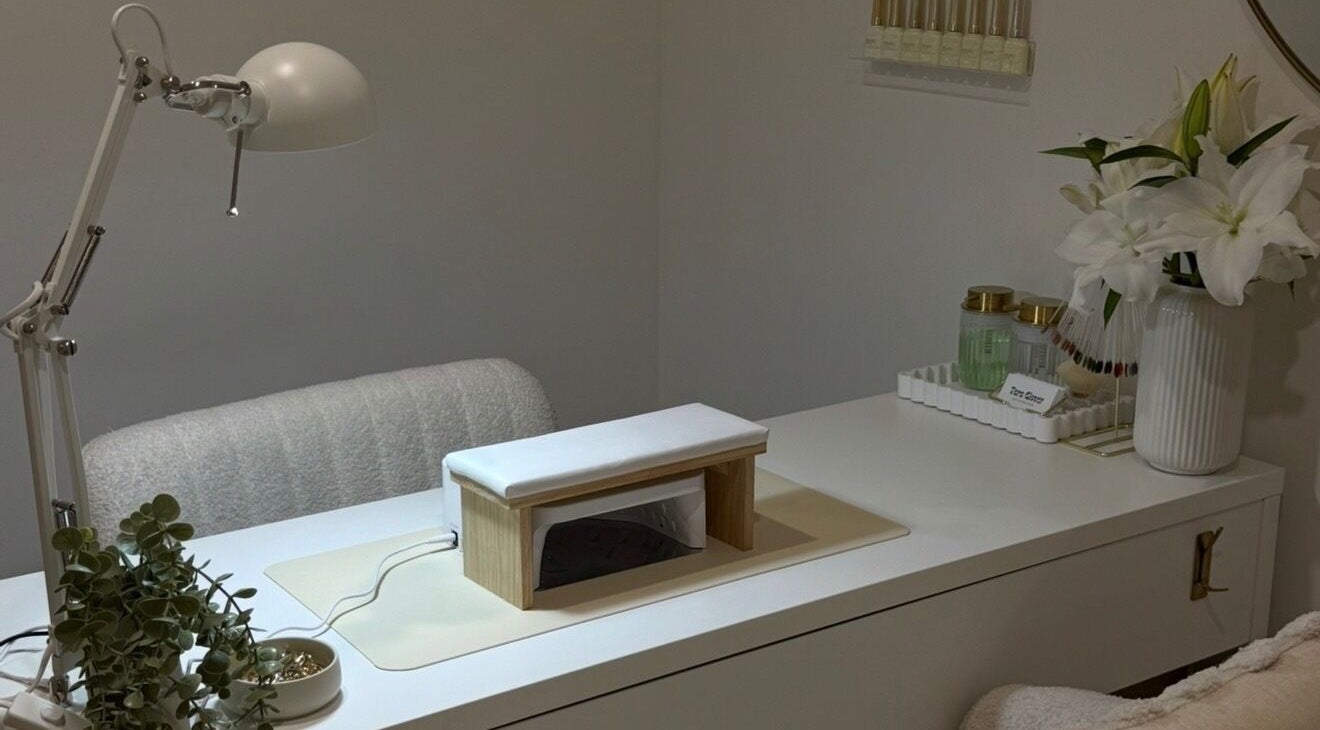 Elegant nail station at Mashed Nails, Melbourne, Victoria, AU with a lamp, white flowers, and a manicure setup.