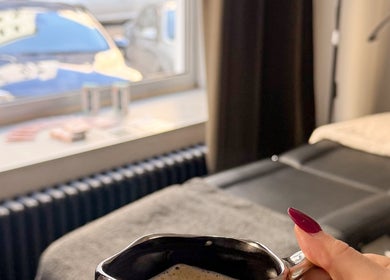 Cozy spa room at Rituals By Nanda, Praha, CZ with a client holding a cup of coffee.
