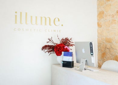 Reception desk at Illume Cosmetic Clinic, Clayfield, Queensland, AU with vibrant red flowers.