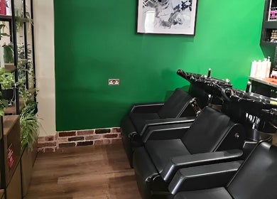 Care Salon seating area with green walls and stylish decor in London, England, GB.