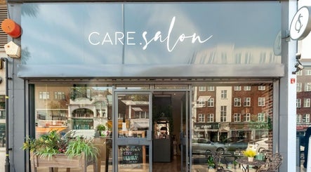 Care Salon entrance with elegant signage in London, England, GB, featuring outdoor seating and greenery.