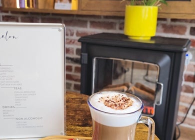 A warm coffee setup at Care Salon, London, England, GB, with a fireplace in the background.