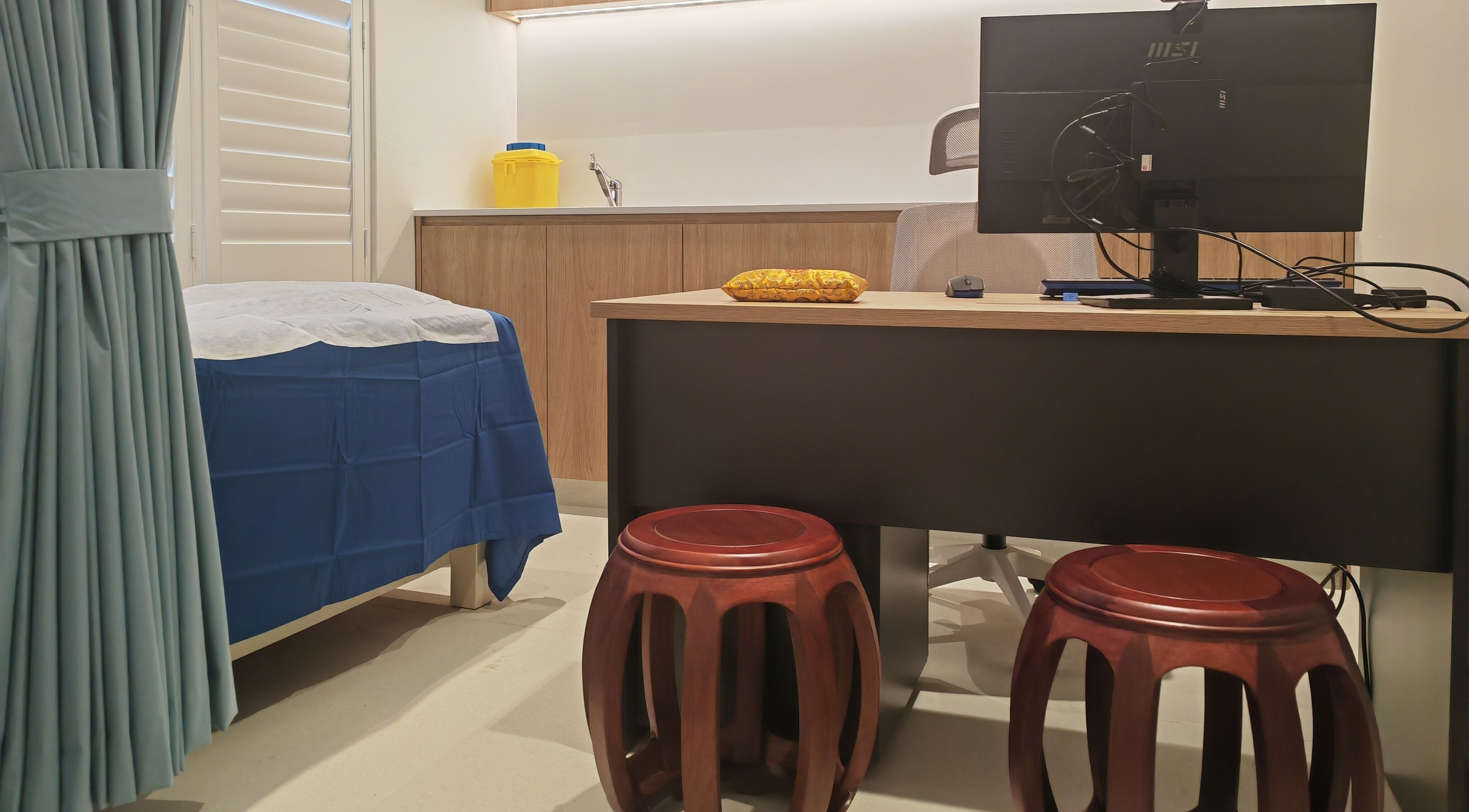 Sydney Chinese Medicine Centre treatment room in Burwood, New South Wales, AU with desk and bed.