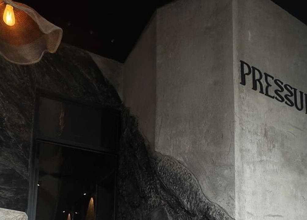 Entrance of Pressure. Massage Spa Bali in Bali, ID with artistic wall design and warm lighting.