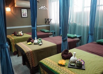 Tranquil massage beds at Siam Thai Massage & Spa, HK, HK, surrounded by calming curtains and warm lighting.