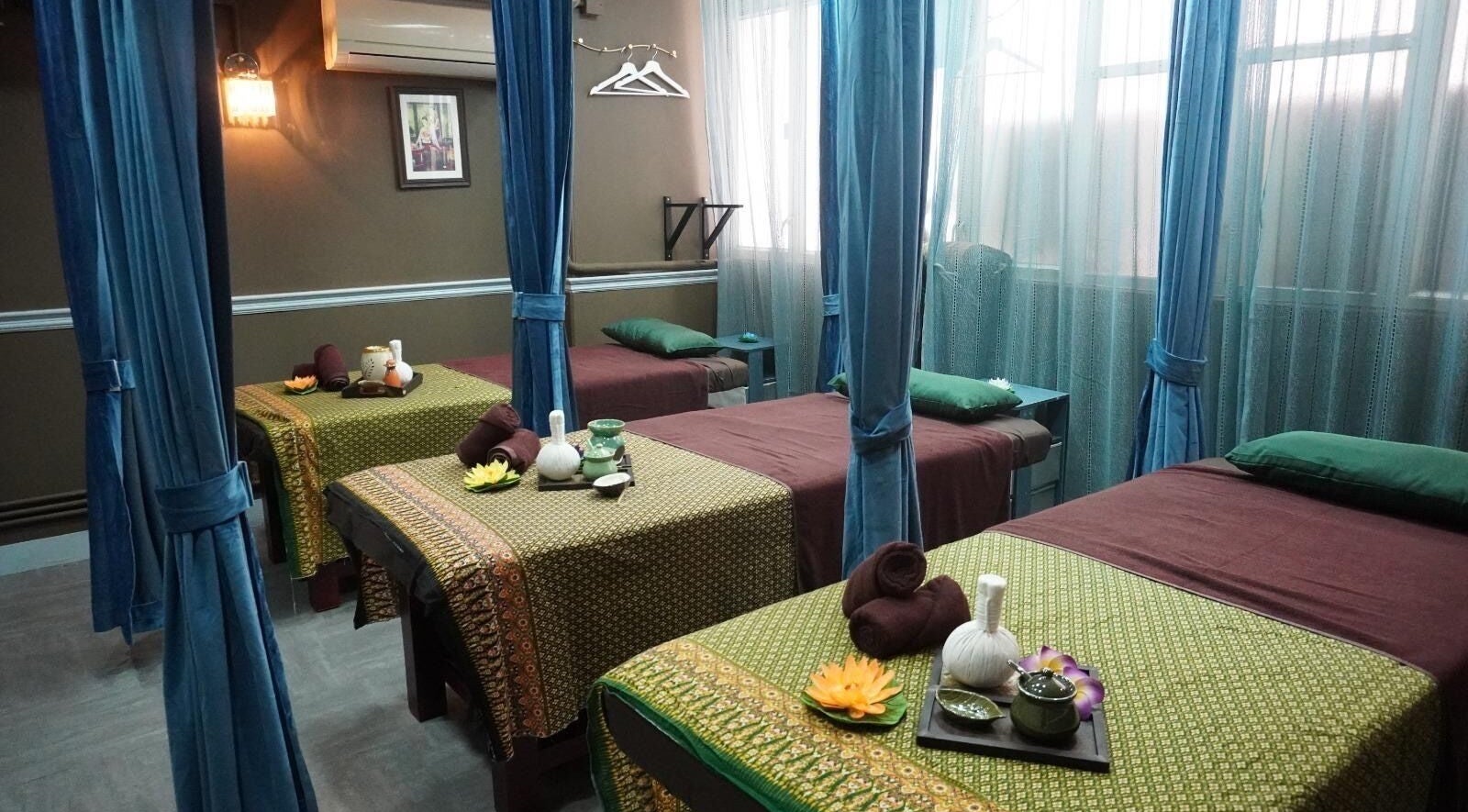 Tranquil massage beds at Siam Thai Massage & Spa, HK, HK, surrounded by calming curtains and warm lighting.